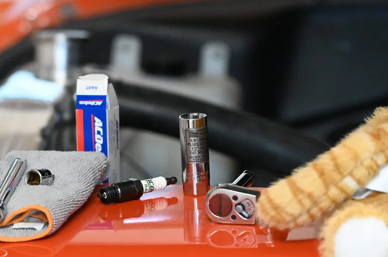 Spark plug and ratchet on left fender next to stunt double cat.